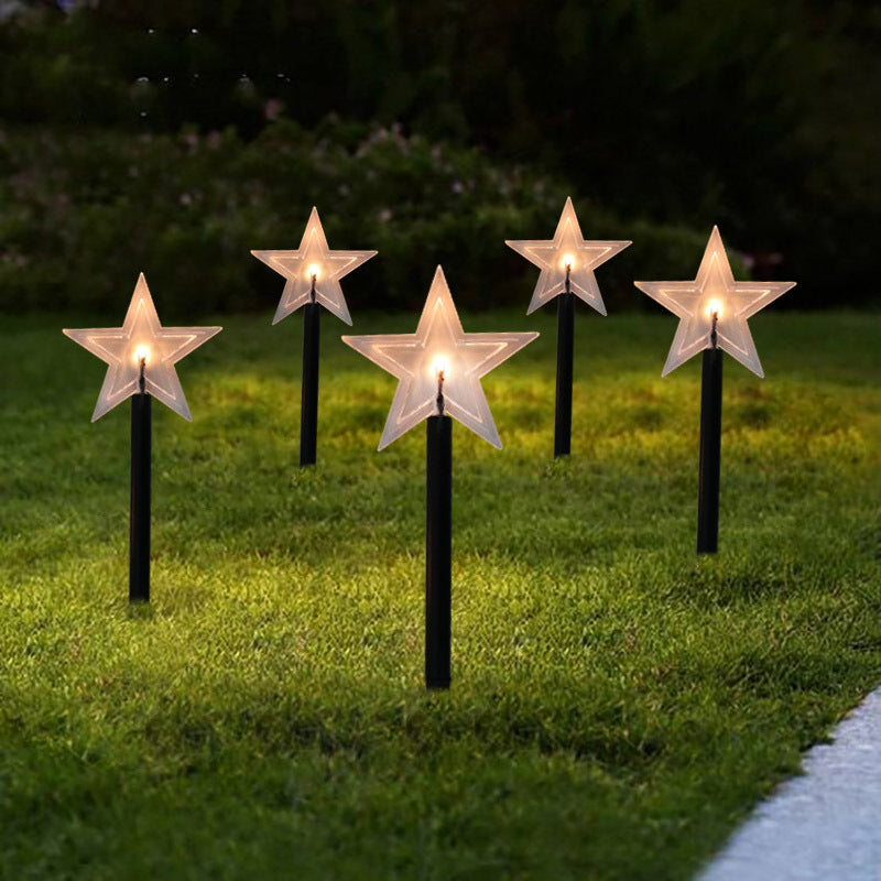 Snowflake-shaped solar garden light glowing softly in winter garden setting