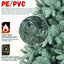 Blue PE/PVC Christmas tree with full ornament display in a cozy living room