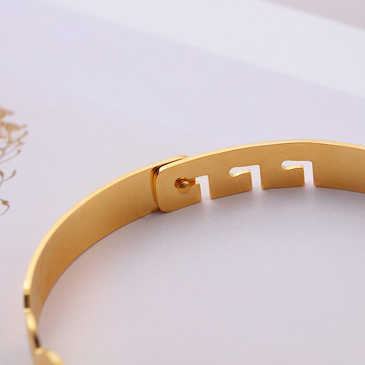 Close-up view of stainless steel scripture bracelet in gold coloring
