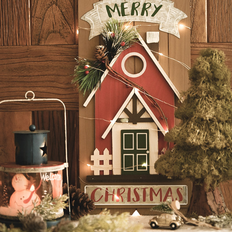 Christmas house wooden ornament displayed on rustic wooden door frame