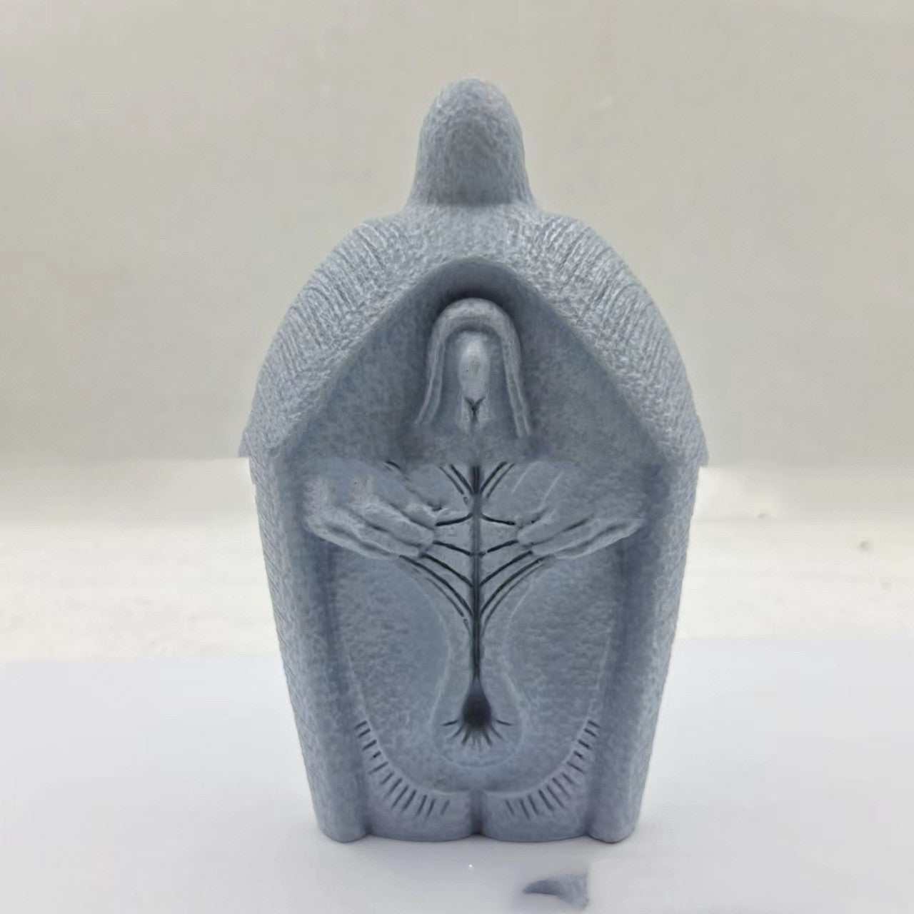 Modern simple resin Jesus ornament hanging against white wall background