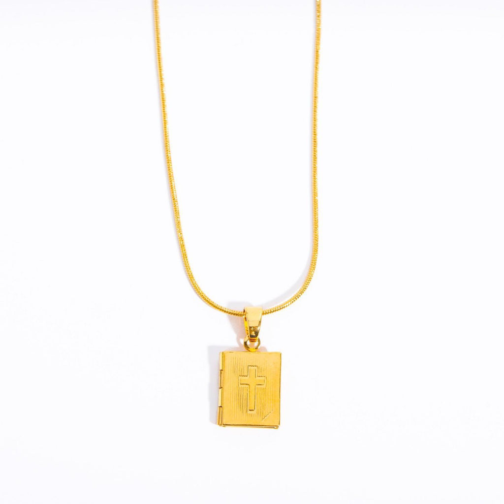 Copper cross pendant necklace displayed on chain