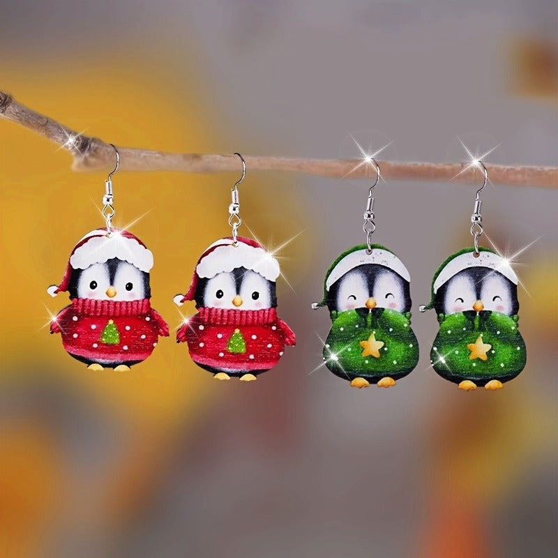 Red and green wooden penguin Christmas earrings hanging on display