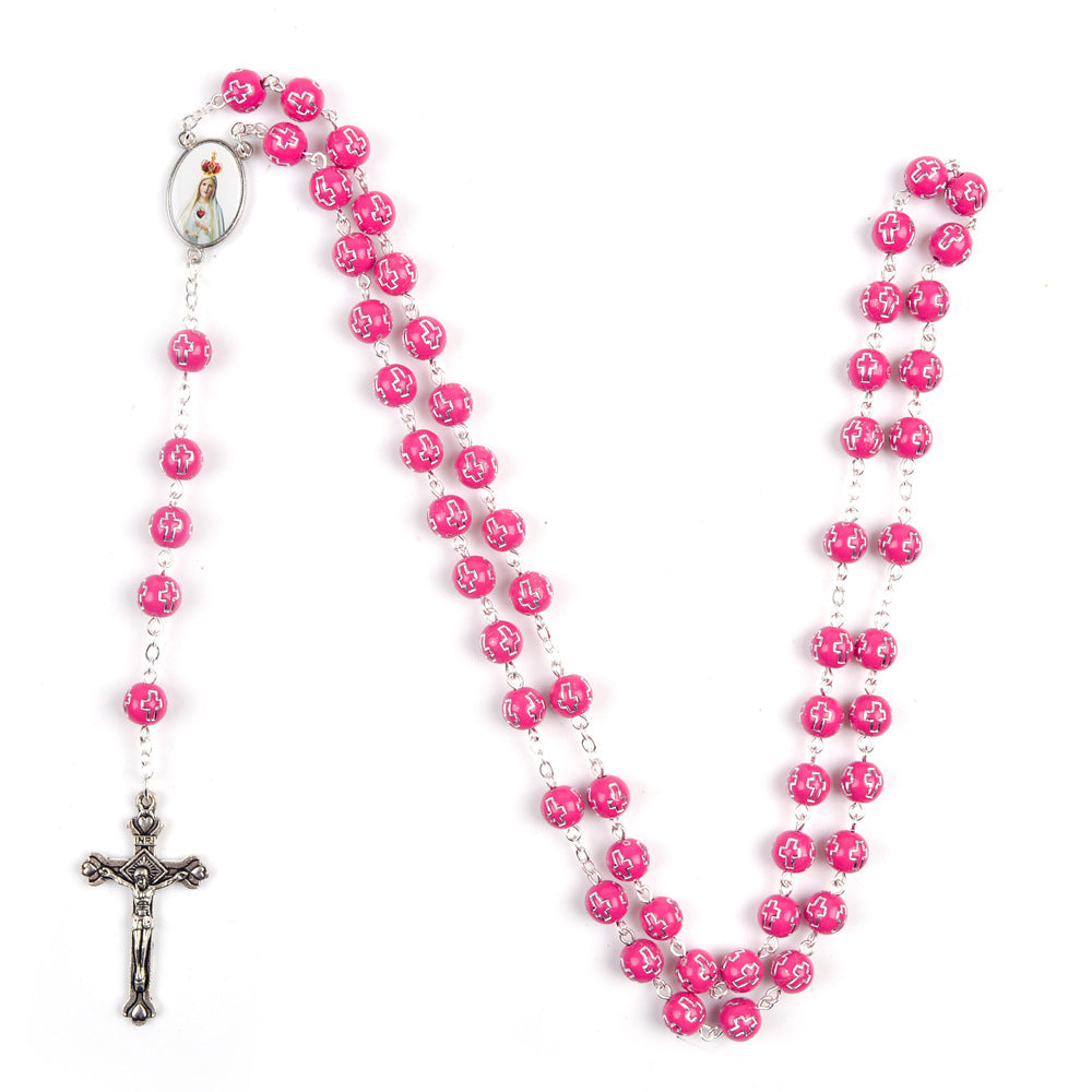 Close-up of Fatima cross and triangle epoxy pendant on acrylic rosary necklace