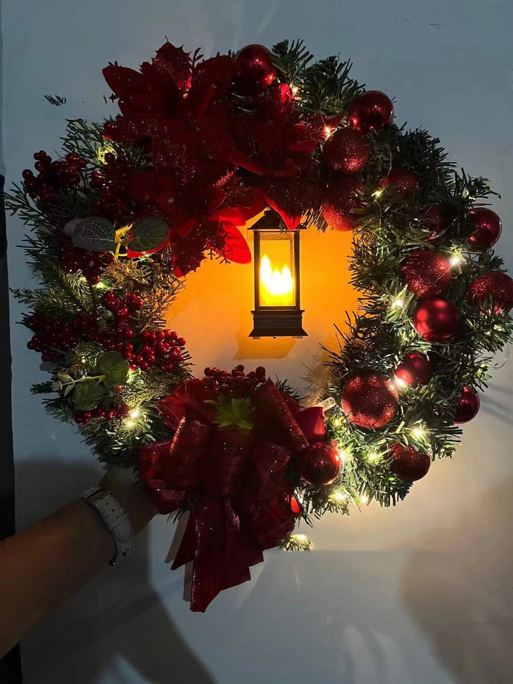 Christmas decorative wreath with Jesus motif and soft white lights against dark background