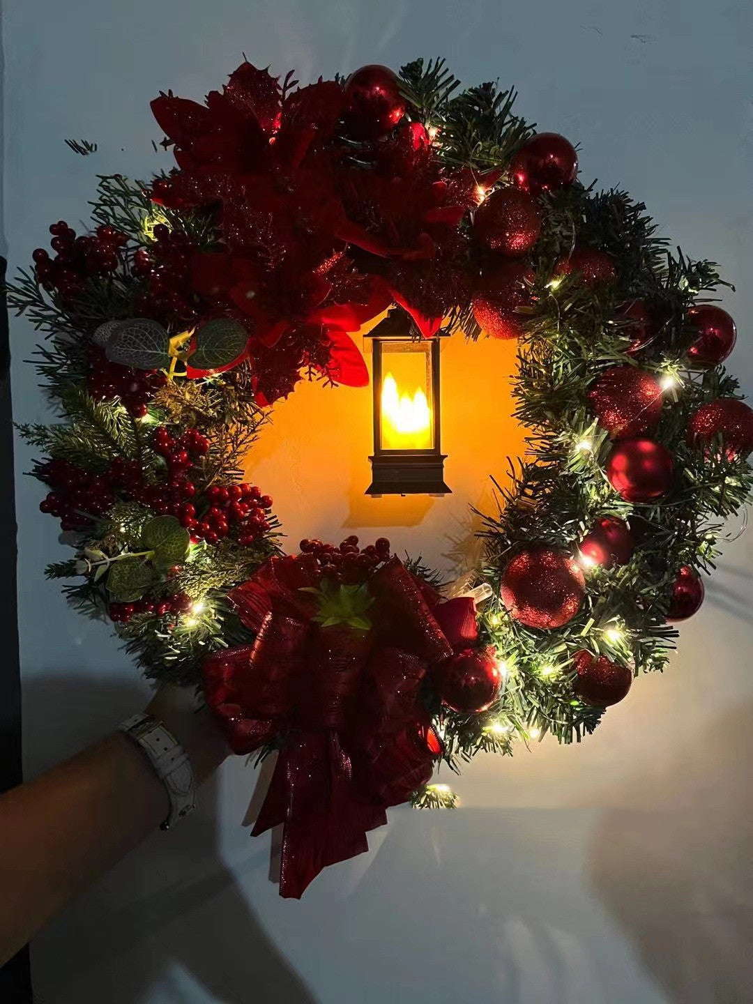 Christmas decorative wreath with Jesus motif and soft white lights against dark background