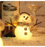 Close-up of glowing ice man ornament with plaid scarf design