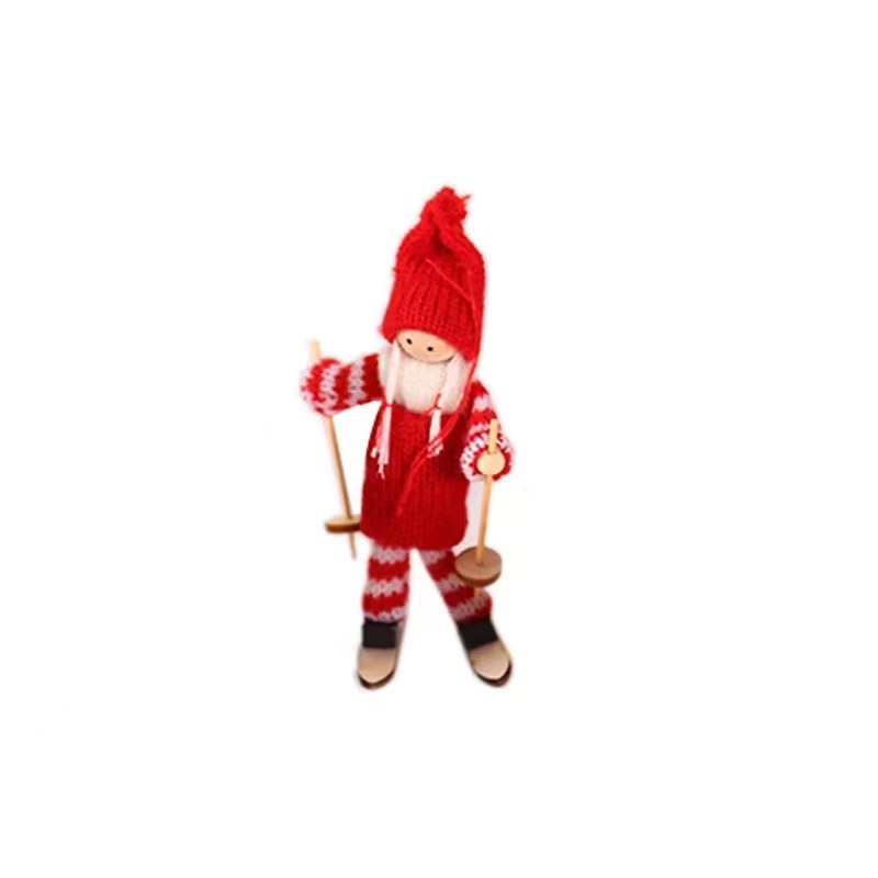 Wooden ski doll ornament placed among festive pine branches and ornaments