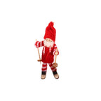 Wooden ski doll ornament placed among festive pine branches and ornaments