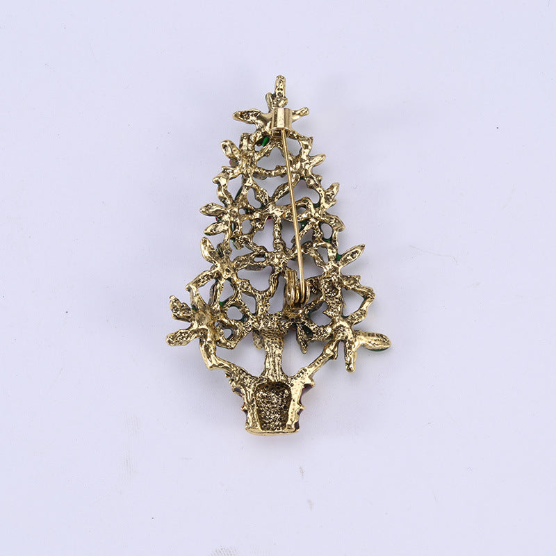 Christmas tree brooch displayed on winter sweater fabric