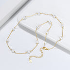 Close-up of pearl accent on silver cross chain necklace