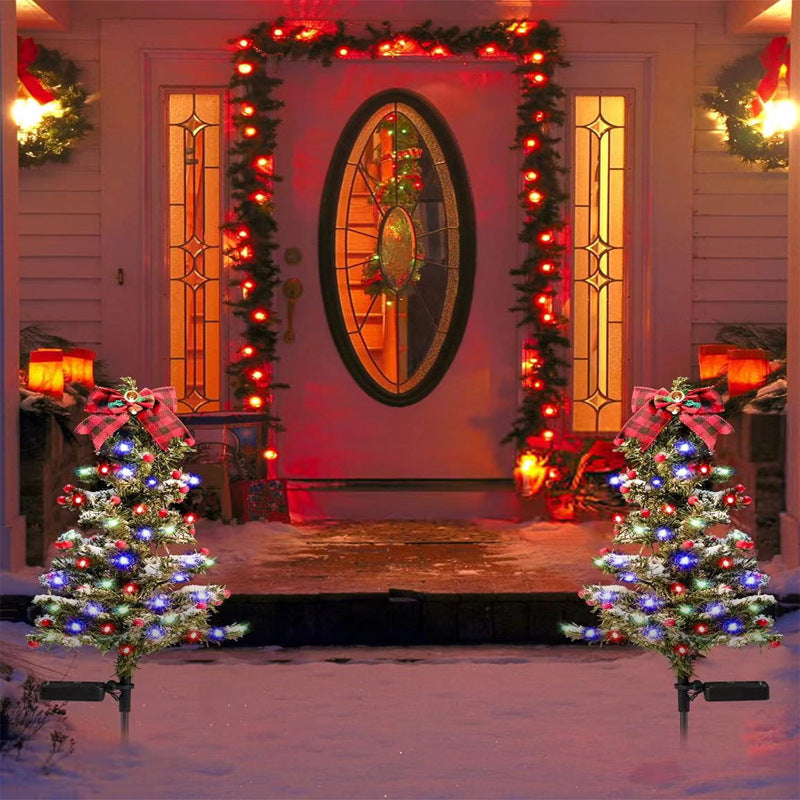 Solar Christmas tree stake light displaying dual lighting modes against a dark winter evening sky