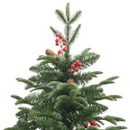 Fully decorated green artificial Christmas tree in a cozy indoor setting with festive ambiance