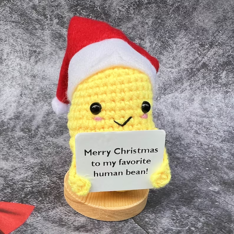 Yellow plush Christmas decoration placed on decorative base in festive setting