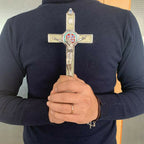 Green glowing St. Benedict cross pendant displayed against dark background