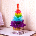 Festive rainbow Christmas tree with string lights and seasonal greenery