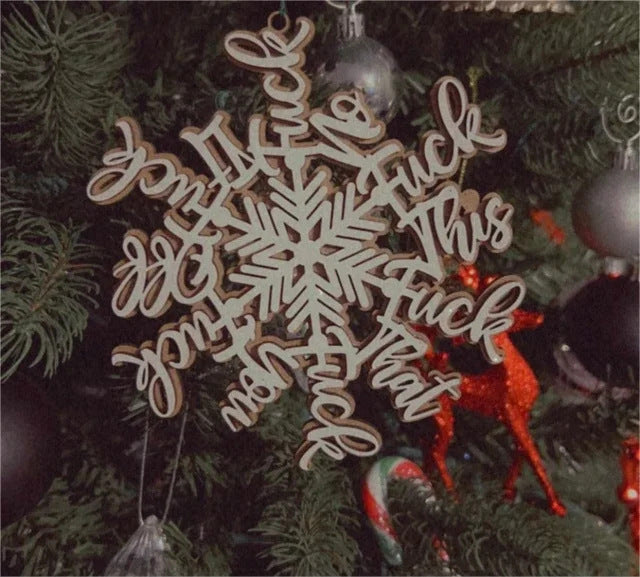 Close-up view of wooden Christmas pendant featuring snowflake and letter shape motif with double-layer depth