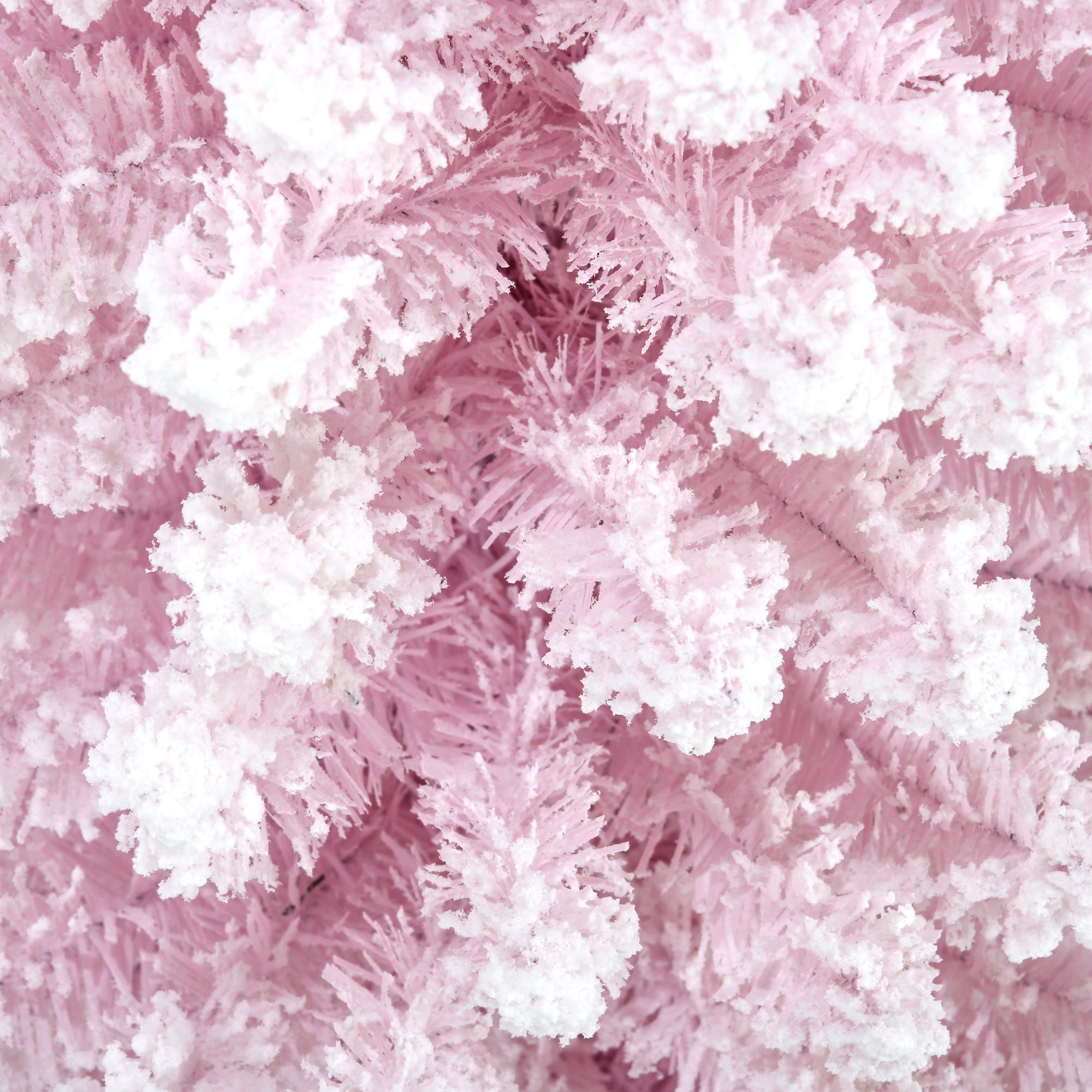 Close-up of snow-flocked branch texture on the pink artificial tree