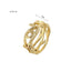 Gold ring featuring crown of thorns and olive branch design on textured surface