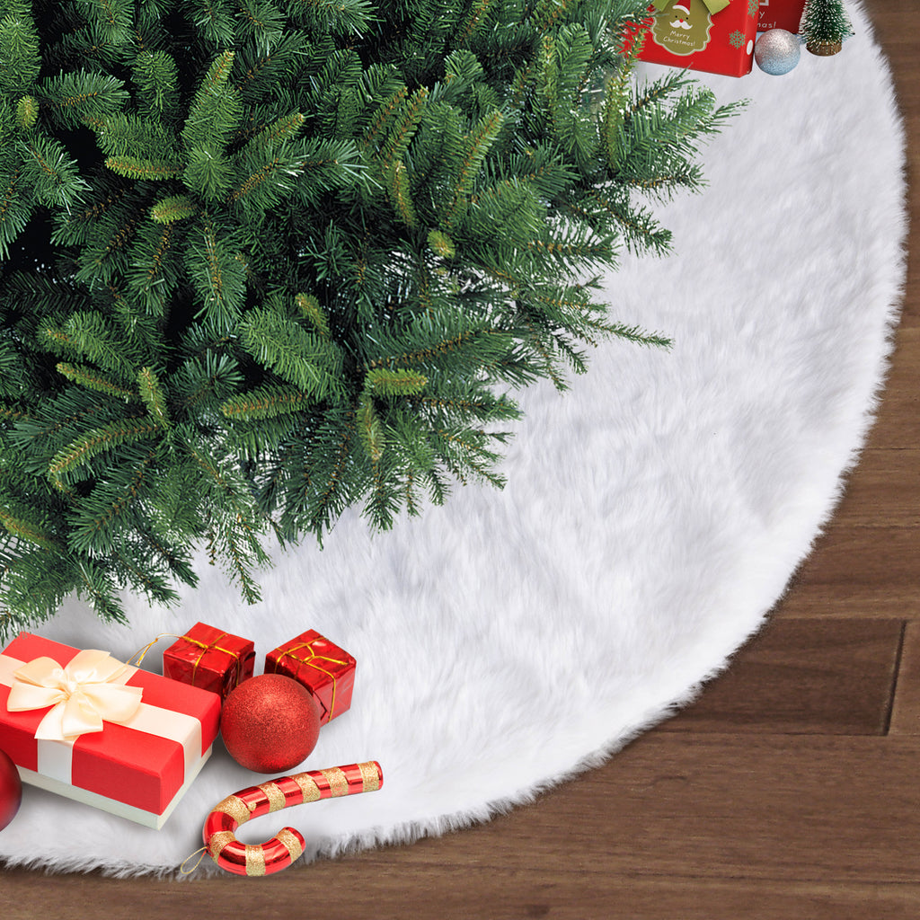 White plush Christmas tree skirt detail showing plush fabric texture on dark floor for Christmas decorating purposes