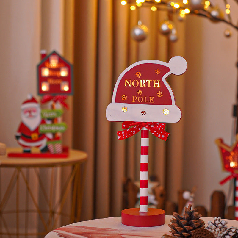 Warm glowing wooden Christmas light shaped like North Pole sign
