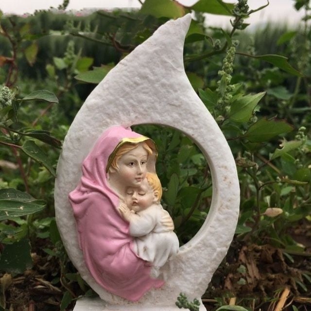 Mary and infant Jesus resin craft ornament displayed in a cozy home setting