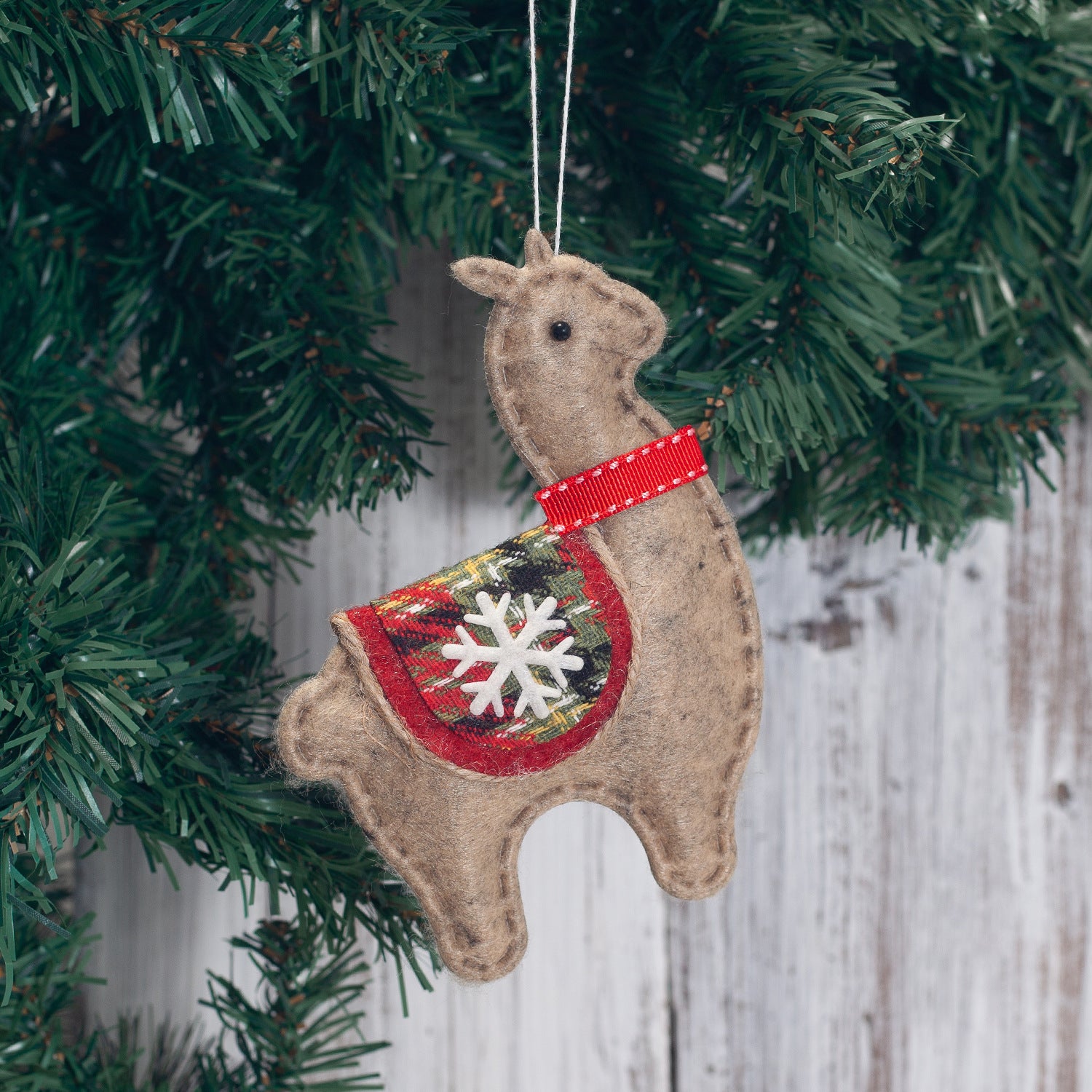 Four alpaca Christmas hanging ornaments displayed together on display