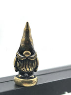 Cozy holiday gnome ornament in brass-tone metal with swaying hinge design