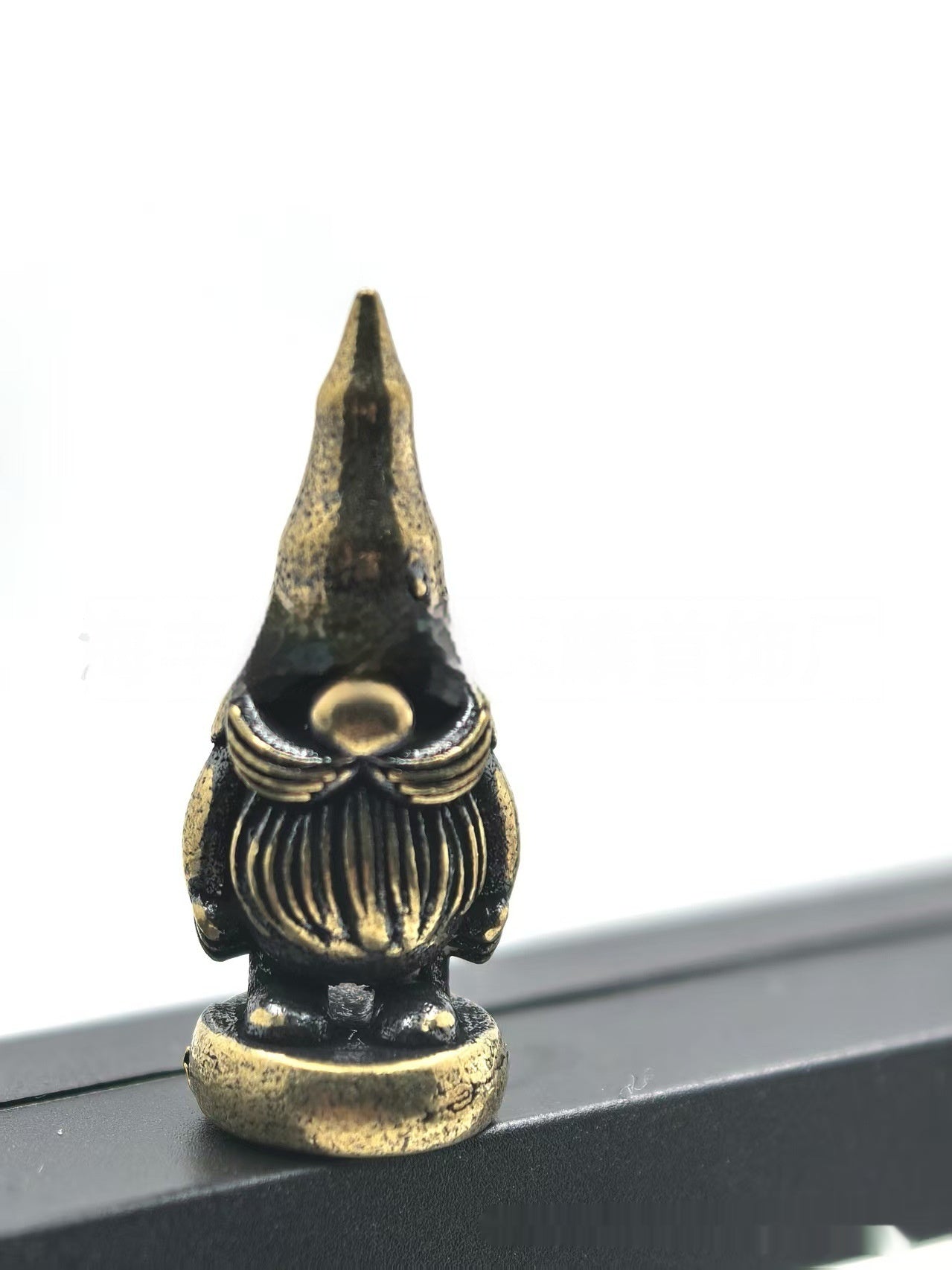Cozy holiday gnome ornament in brass-tone metal with swaying hinge design