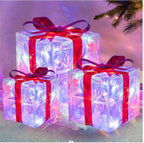 Stacked glowing Christmas gift boxes creating festive window display