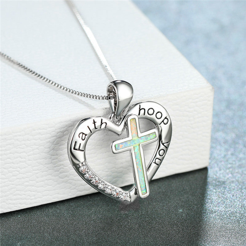 White heart-shaped cross pendant necklace displayed on a clean white background