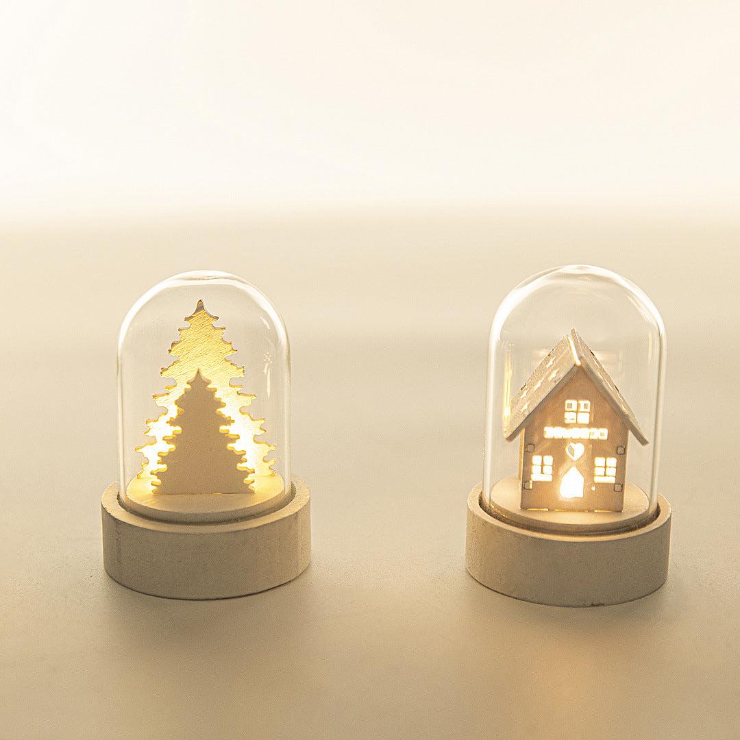 Luminous wooden house Christmas ornament glowing warmly on Christmas tree branches