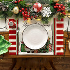 Four linen placemats arranged as a coordinated Christmas table setting