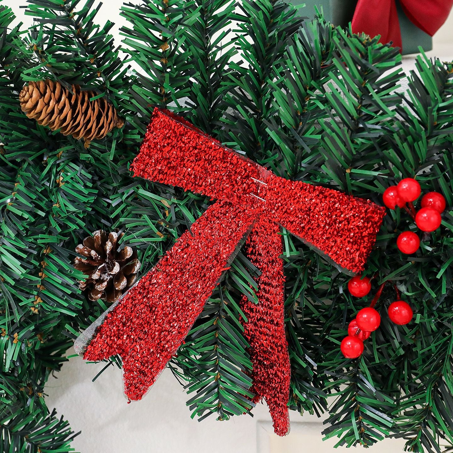 Rattan pine cone bow Christmas decoration arranged on white surface with warm holiday ambiance
