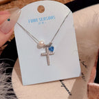 Silver cross pendant necklace with pearl and zircon detail view