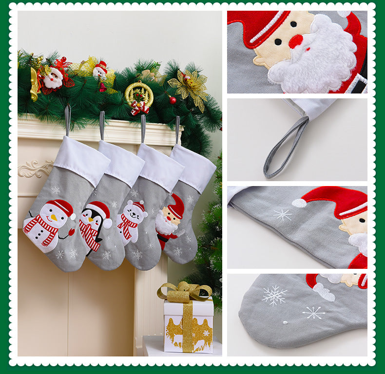 Set of four gray embroidered Christmas stockings featuring penguin bear Santa and snowman designs