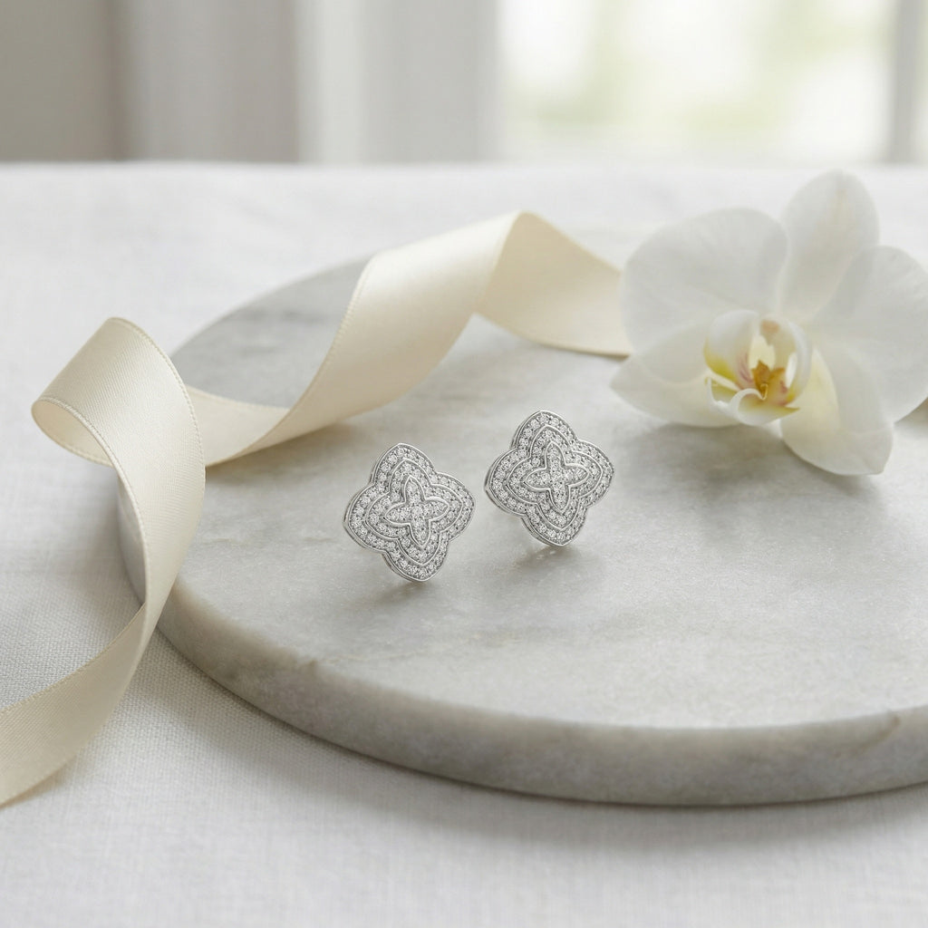 Classic diamond cluster stud earrings featuring religious quatrefoil motif in polished silver
