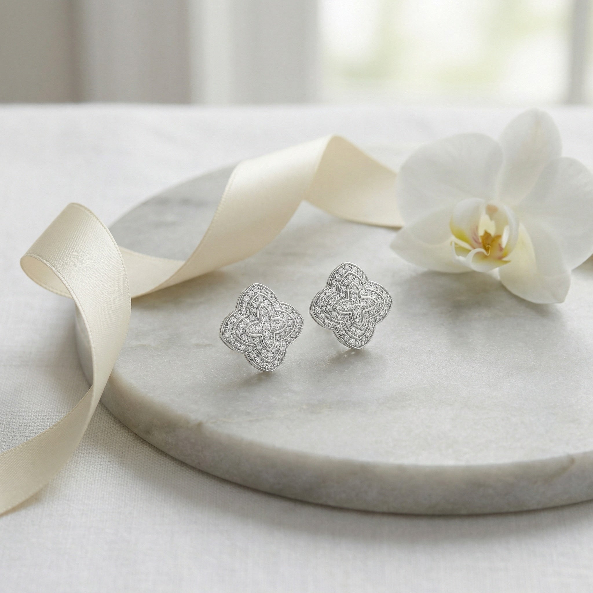 Classic diamond cluster stud earrings featuring religious quatrefoil motif in polished silver