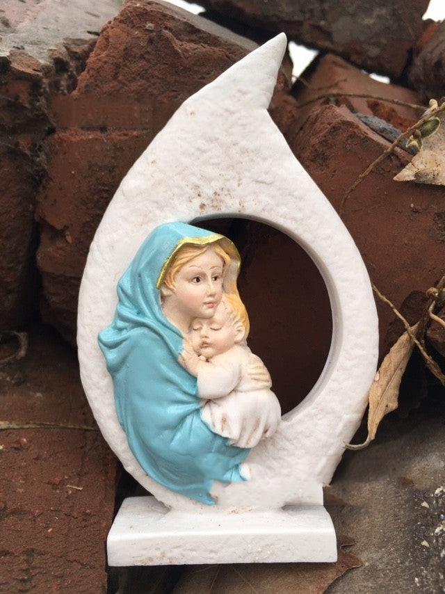 Close-up detail of hand painted Virgin Mary holding baby Jesus figurine