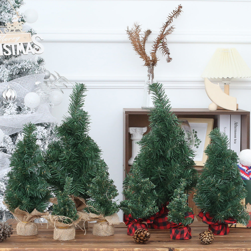 Compact PVC Christmas tree in linen finish standing on desktop with winter light, festive window decoration