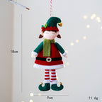 Cute cartoon elf doll hanging ornament on Christmas tree with ribbon