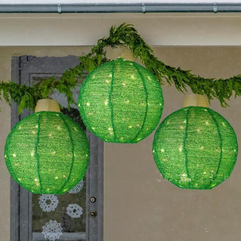 Golden lantern pendant ornament with intricate cut details catching light against dark backdrop
