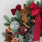 Illuminated Christmas wreath with warm glow highlighting pine cones and bow