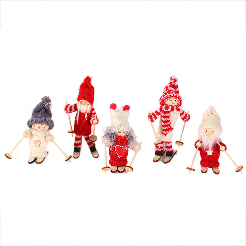 Wooden ski doll ornament in white clothes with grey hat next to Christmas greenery