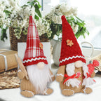 Christmas tree branch displaying multiple knitted elderly ornaments with holiday greenery