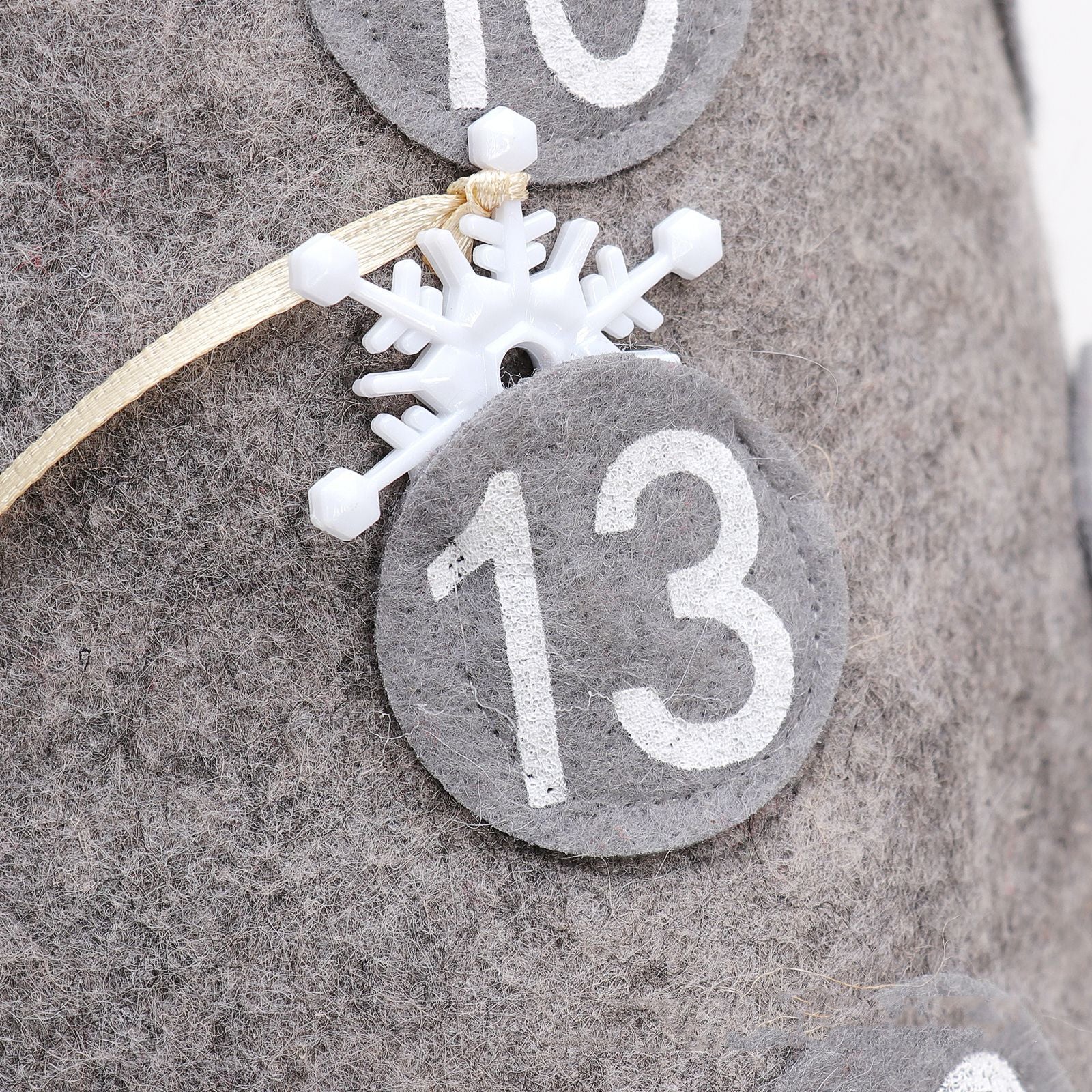 Christmas countdown doll displayed on snowy mantelpiece with other holiday decorations