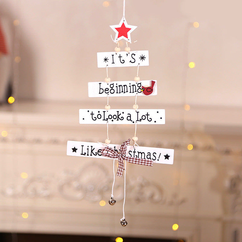 Wooden Christmas pendant star hanging with red ribbon on tree branch