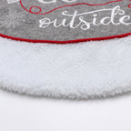 Festive Christmas tree base decorated with gloves pattern tree skirt in a cozy winter setting