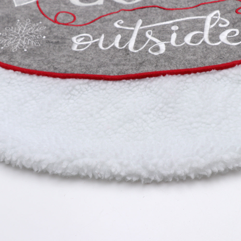 Festive Christmas tree base decorated with gloves pattern tree skirt in a cozy winter setting