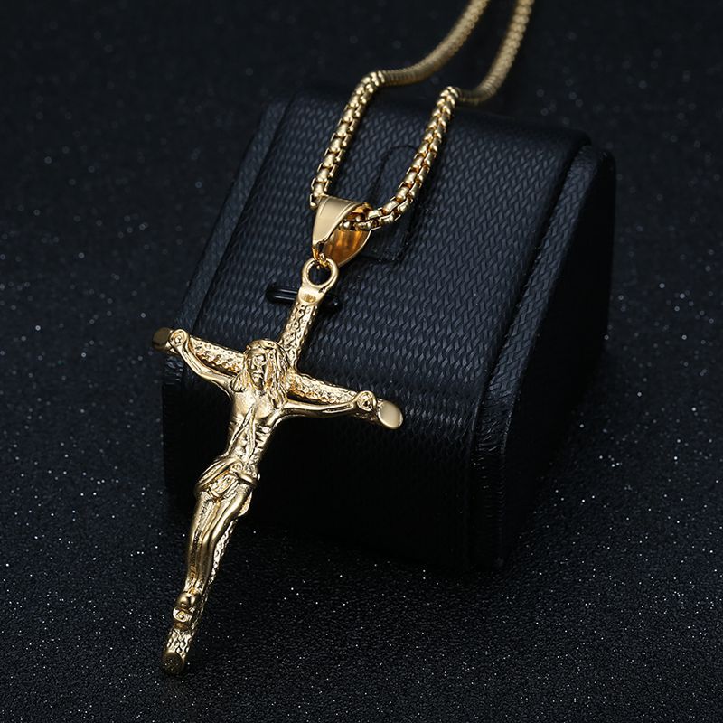 Gilded titanium steel cross pendant catching light
